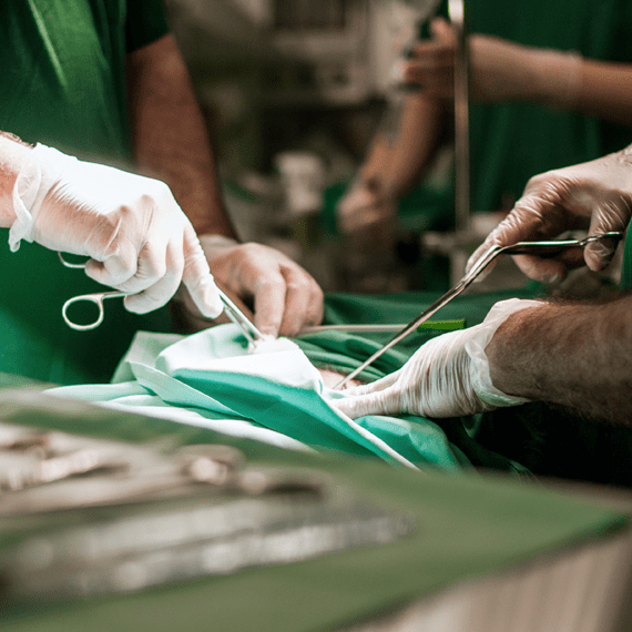 A surgeon in scrubs performing surgery on a patient